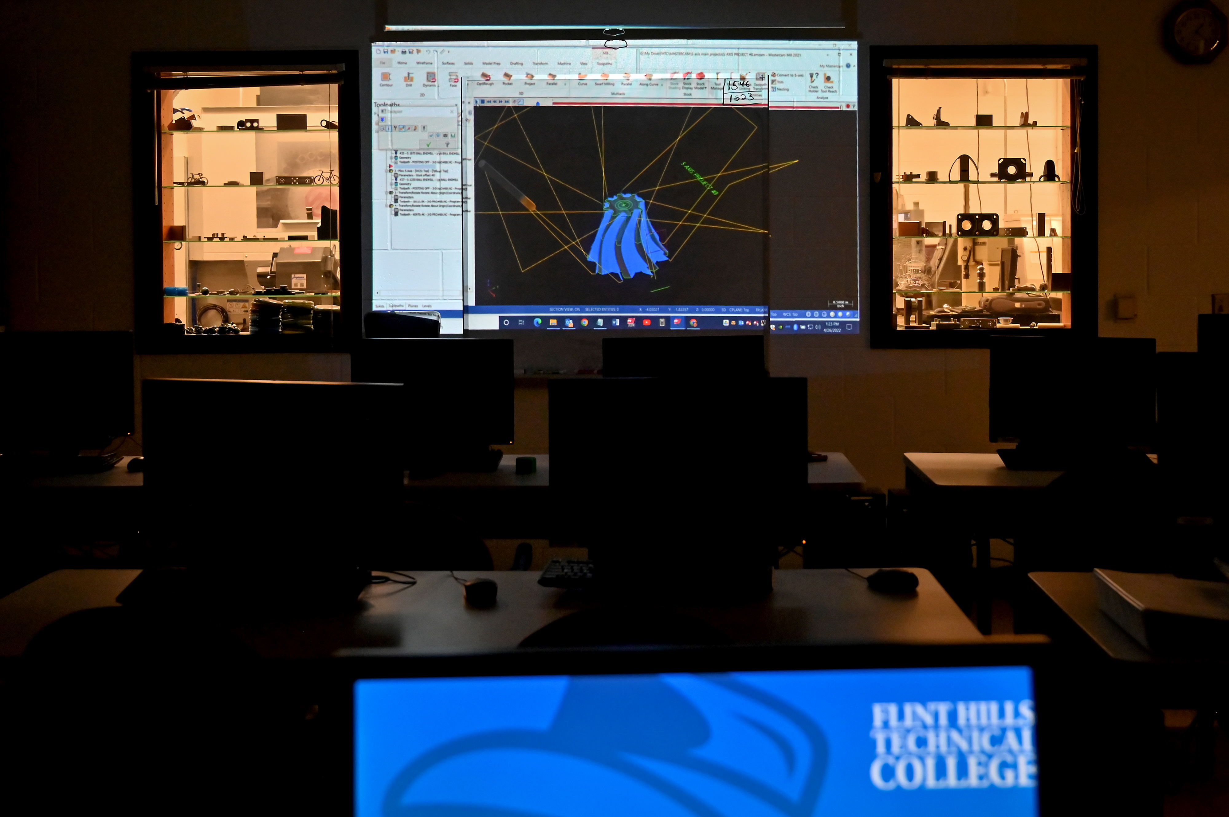 A darkened technical classroom at Flint Hills Technical College with a CAD model on a projection screen