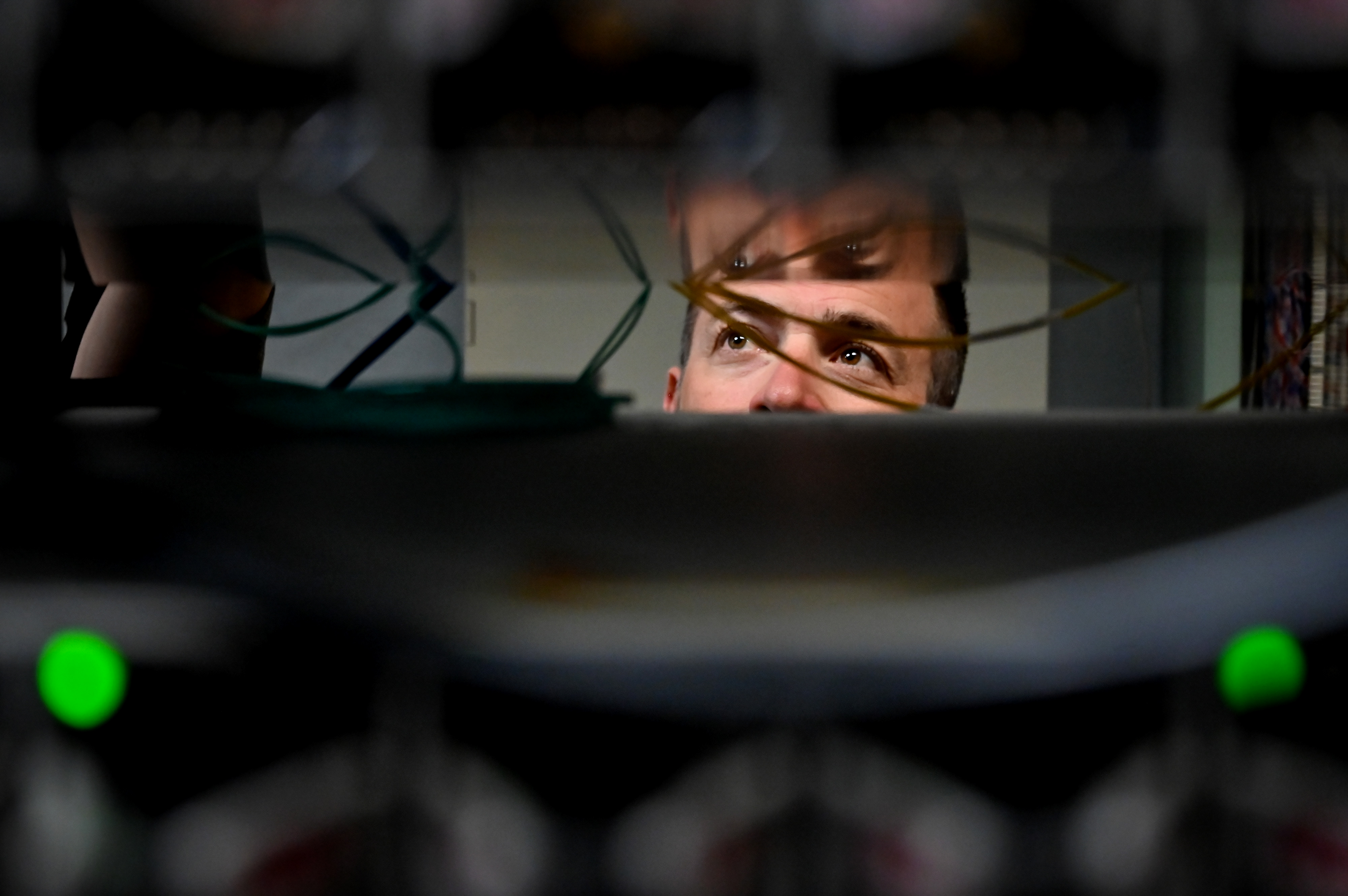 A technician peering through server equipment in a data center